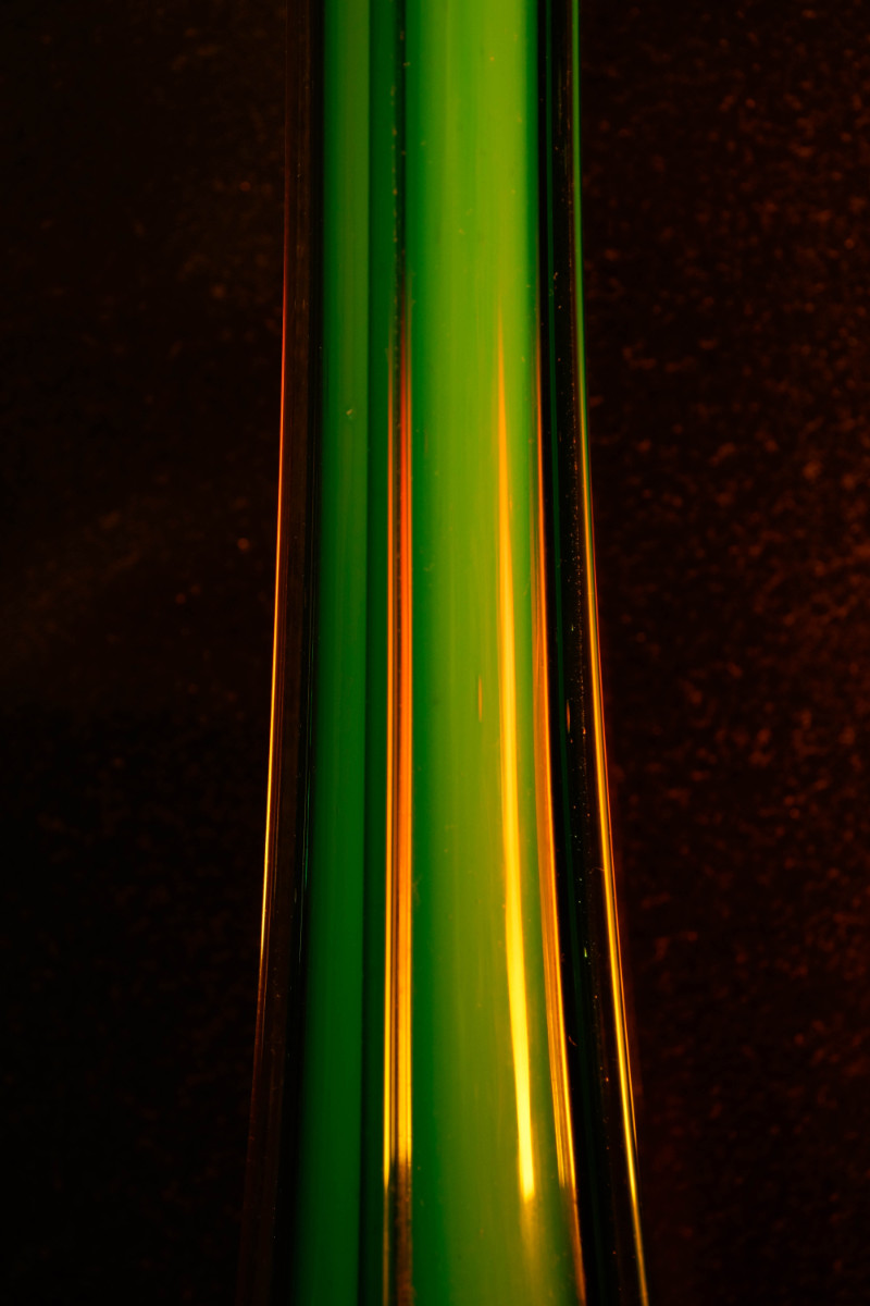 An abstract image of a green glass tube with orange highlights